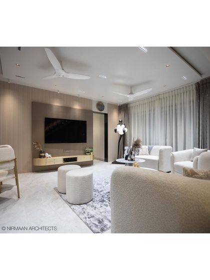 The living room of our Duplex Project is designed with a neutral palette of whites and beiges, creating a calm and expansive feel. The sculptural floor lamp adds a touch of artistic flair.