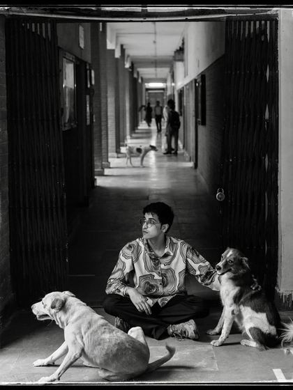 Tanishque, sitting with stray dogs in a corridor. This image is very close to my heart, capturing a moment of quiet empathy and shared space.