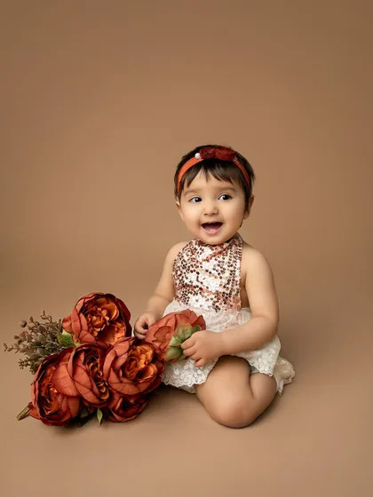 A happy giggle from the birthday girl. Her joy is infectious in this portrait from her rust and floral themed first birthday photoshoot.