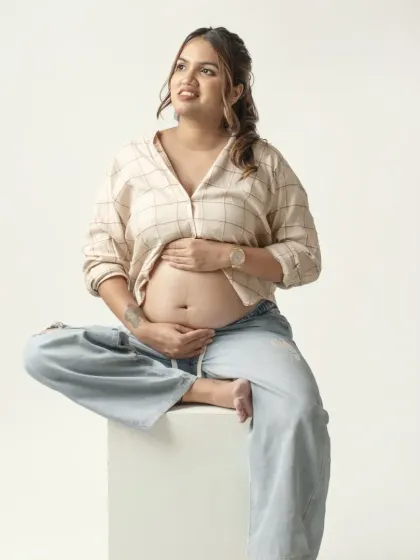 A relaxed and happy portrait of a mom to be in a casual, stylish outfit. This shot captures her comfortable and confident attitude during her pregnancy.