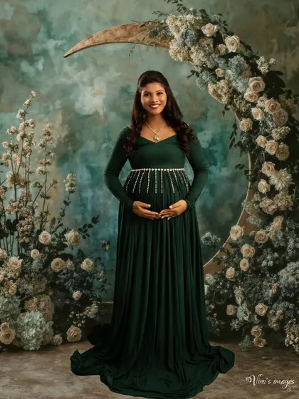 A beautiful portrait set against a crescent moon floral arrangement. The dark green gown and the dreamy backdrop create a magical, celestial vibe.