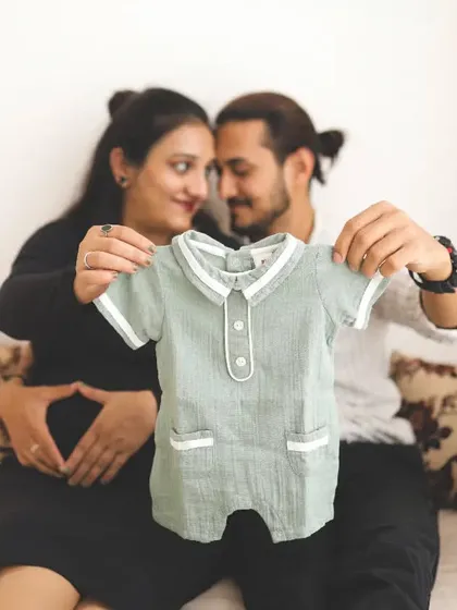 The sweetest baby announcement. Holding up a tiny outfit is such a lovely way to share the news and capture the excitement of what's to come.
