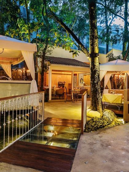 Our outdoor space during the day, highlighting the beautiful bridge over the water feature and the lush greenery that makes it an oasis.