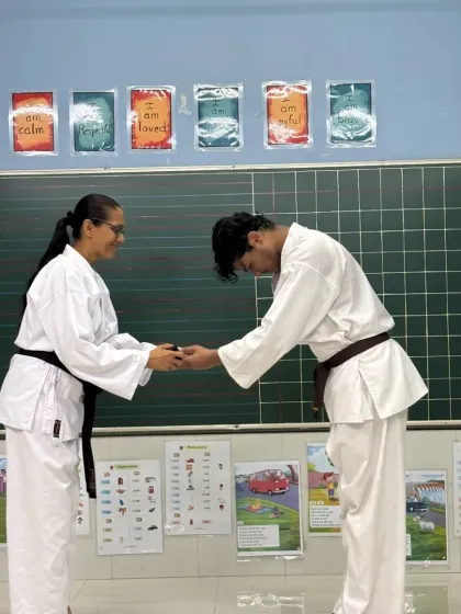 The journey to a black belt is marked by many steps. Here, a student receives his brown belt, one of the final and most challenging ranks before achieving Shodan, signifying his advanced skill and dedication.