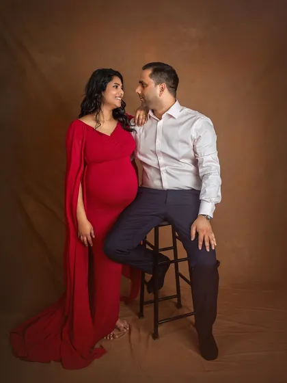 A classic studio portrait of the couple. The contrast between her vibrant red gown and his crisp white shirt creates a timeless and elegant look.
