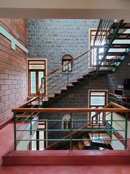 I love to let natural materials converse with each other. In this space, the cool grey of the stone wall, the warm red of the hollow clay blocks, and the rich tones of the wooden staircase create a balanced and harmonious interior.