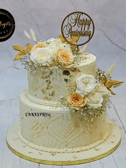 A breathtaking 5kg two-tiered anniversary cake with an engraved floral pattern. This elegant creation is decorated with fresh flowers and delicate fern accents.
