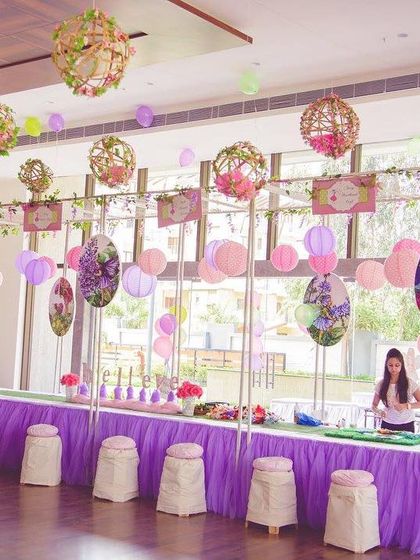 An arts and crafts station for a magical fairy-themed party. The hanging floral spheres and organized supplies invited the little guests to get creative.