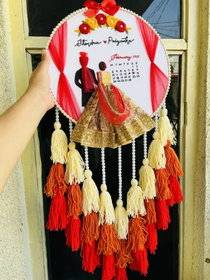 I craft detailed wedding embroidery hoops that capture the essence of your special day. This piece features a custom portrait, names, and a calendar marking the wedding date, all brought to life with 3D fabric elements and colorful tassels.