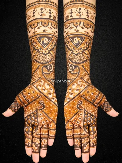 A unique bridal design featuring Warli art figures at the top, blended with traditional peacock and geometric patterns.