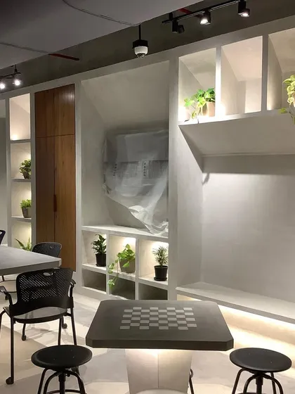 Even small touches of green make a difference. We placed a variety of small, low-maintenance plants in these illuminated shelves to warm up the office breakroom.