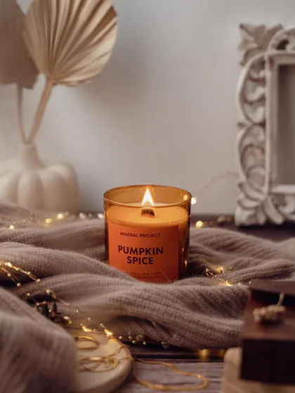 A cozy, autumn-themed lifestyle shot for a pumpkin spice candle. I used soft textiles, fairy lights, and a warm color palette to evoke a feeling of comfort and relaxation.
