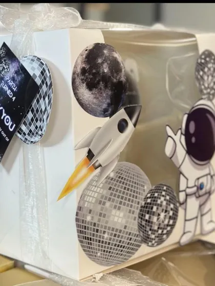 Out of this world return favours for a space themed party. This astronaut projector lamp is packaged in a custom box with a 'Thank You' tag.