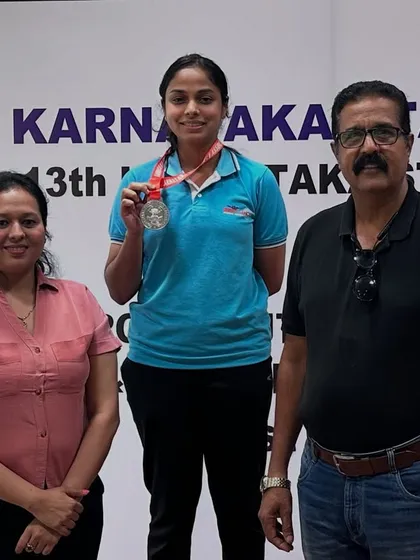 A moment of pride for our shooter and her parents on the podium after winning a medal in the Air Pistol event.
