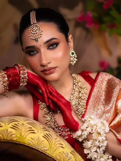 An artistic and powerful bridal portrait. The combination of traditional temple jewellery with bold red alta-painted hands creates a visually stunning look that honors heritage with a modern artistic flair.