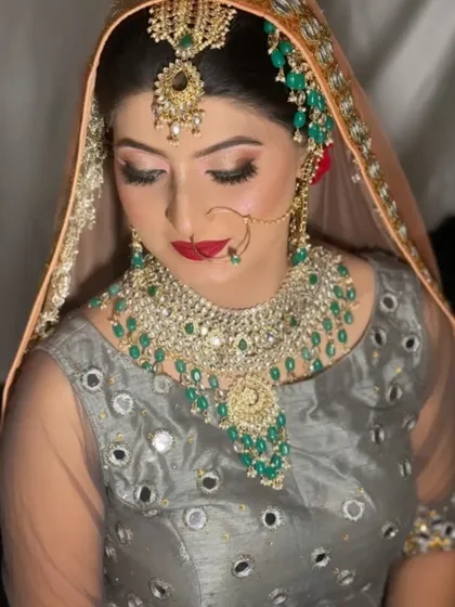 The complete look of our Pakistani bride with her dupatta set. The makeup, with its matte red lip and defined eyes, stands out beautifully against the grey and peach outfit.