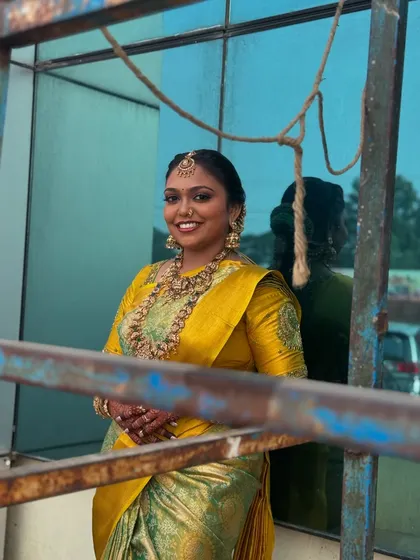 A happy outdoor portrait of Prithivi. Her makeup looks fresh and vibrant, and her smile is infectious, capturing the essence of a joyful bride.