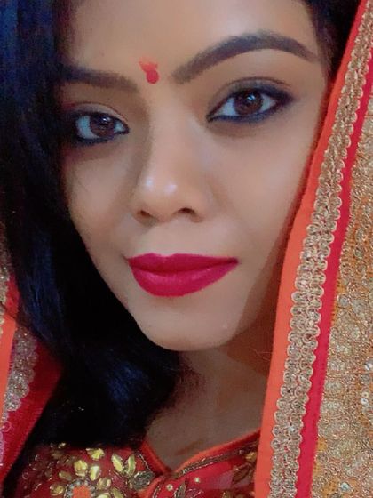 A festive close-up, with the dupatta framing the face. The red bindi and bold lipstick complete the celebratory look.