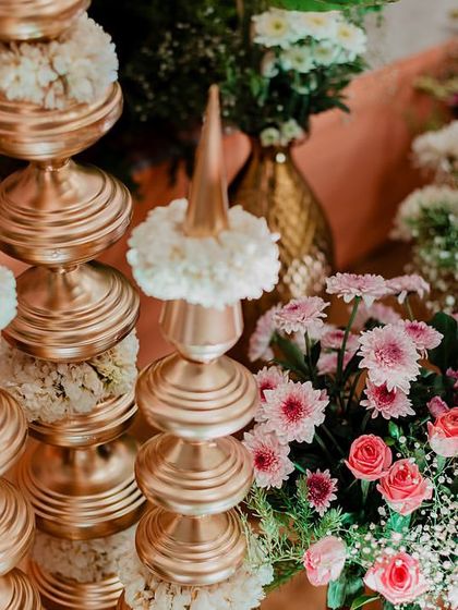A close-up of the elegant golden and floral decor elements from a traditional wedding ceremony.