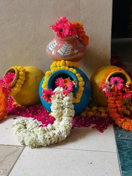 We create beautiful traditional decor pieces like these decorated pots with overflowing marigold and rose garlands, perfect for entrances and walkways.