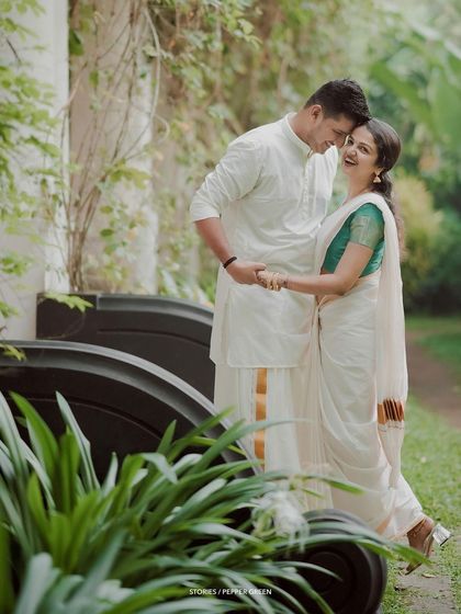A sweet, candid moment of the couple sharing a laugh in a garden setting.