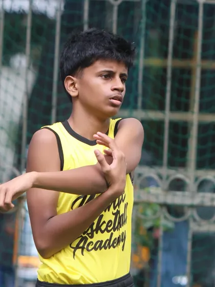A player stretches his arm, preparing for a training session. We teach the importance of physical preparedness and injury prevention.