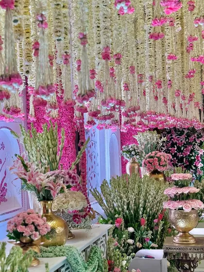 A closer look at the symphony of textures and colors. Cascading florals, vibrant pink blooms, and hammered gold vases come together to create a setting that is nothing short of a dream. 🪷