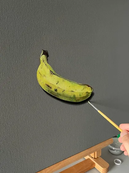 A realistic painting of a single banana on canvas. I used acrylics to capture the subtle color variations and texture of the banana peel.