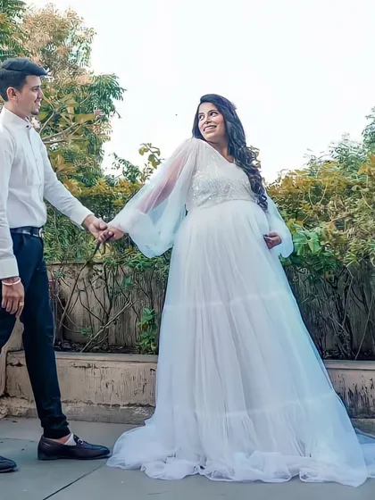 This white flare gown is perfect for a baby shower or an angelic maternity shoot. It features a sequined bodice and dramatic long balloon sleeves for a touch of whimsy.