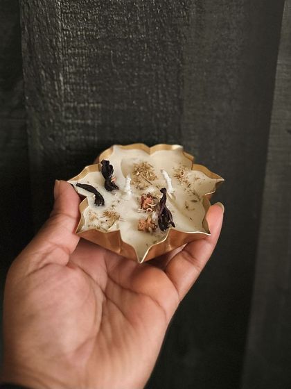 A small, delicate urli candle held in my hand. These are great for adding to gift hampers or for creating an array of floating lights in a larger water vessel.