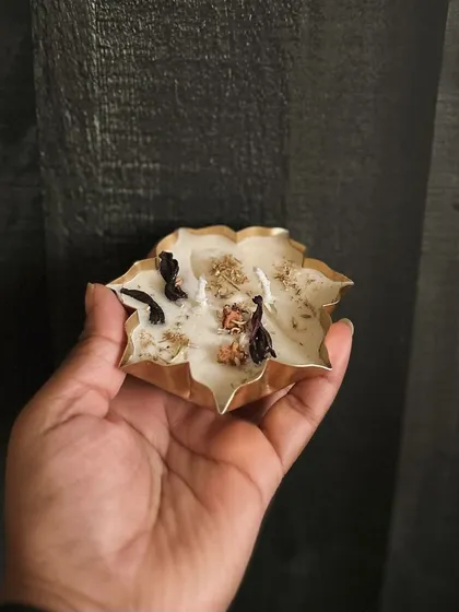 A small, delicate urli candle held in my hand. These are great for adding to gift hampers or for creating an array of floating lights in a larger water vessel.