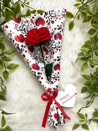 A single red rose wrapped in cute heart-patterned paper, with a little "Happy Anniversary" tag. It’s the small, personal touches that make a gift special.