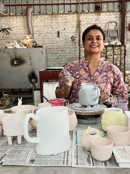 Here is a student in the middle of a glazing session, surrounded by her bisque-fired pieces. This is the stage where you add personality and color before the final firing.