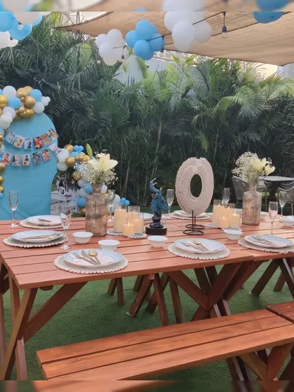 The complete outdoor setup for a memorable first birthday, combining rustic picnic tables with elegant decorations.