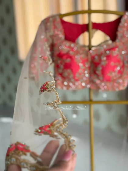 A delicate net dupatta with a scalloped border, featuring fine zardosi and threadwork embroidery that perfectly complements the heavy bridal blouse.