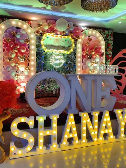 A different angle of the Shanaya's butterfly-themed stage, showcasing the 'ONE' table and decor.