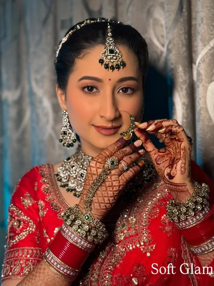 A perfect example of a soft glam red bridal look. The makeup is subtle yet defining, allowing the bride's natural beauty and her stunning red outfit to take center stage.