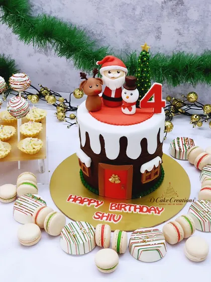 A festive Christmas-themed dessert spread, featuring a Santa's cottage cake, macarons, and cakesicles for Shiv's 4th birthday.