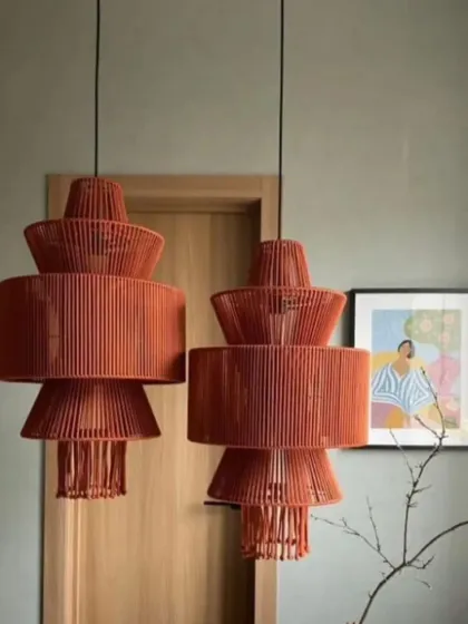 Two of our tiered, terracotta-colored pendant lights hanging side-by-side. The stacked design adds a sculptural element, making them a stylish choice for adding a pop of color and modern design to a space.