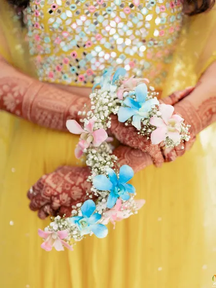 A close-up of one of our pastel floral jewellery sets. I love playing with soft colours like pink and blue, using delicate orchids and baby's breath to create a modern and dreamy look for Haldi or Mehendi.