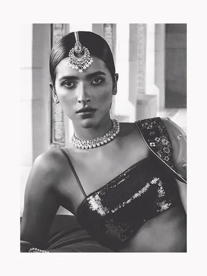 This black and white portrait captures the timeless, old-world elegance I love to create. The focus is on the clean silhouette, statement maang tikka, and the model's powerful gaze, showing that style is an attitude.
