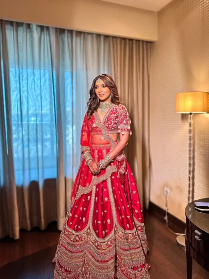 A full-length shot of Priyanka in her stunning red lehenga. The makeup was designed to complement her outfit, with a focus on radiant skin that looks beautiful in any light.