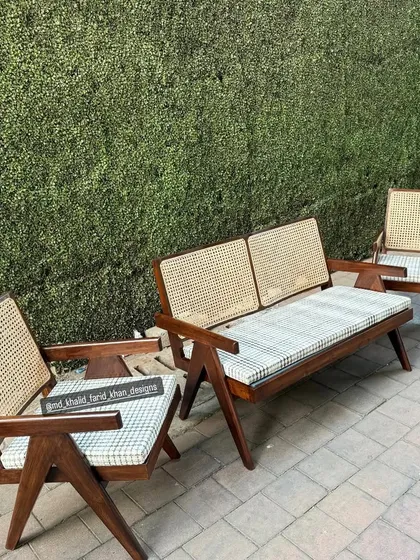A clear shot of the Jeanneret set against a green wall.