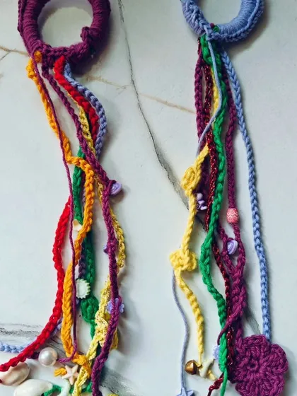 A pair of my more elaborate hair extensions, featuring multiple strands of different colors, textures, and charms like pearls, shells, and tiny crochet hearts. These are truly a statement piece.