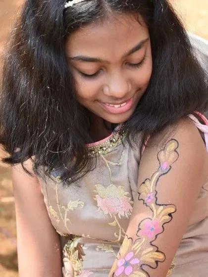 Look at that happy smile. This young guest is admiring her new floral arm painting. My face and arm painting service is always a hit, offering creative designs that let kids express themselves.