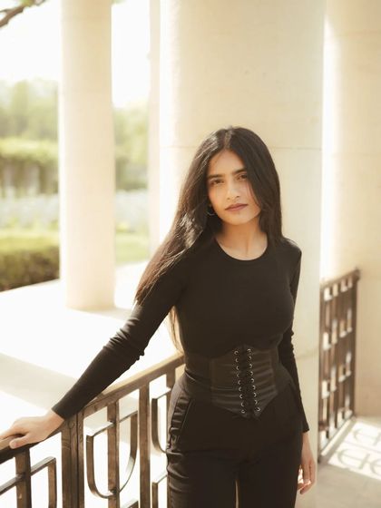 A simple and direct portrait from the same series, with the subject leaning against a railing. The clean background and natural light keep the focus entirely on the person.