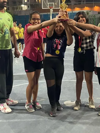 The girls' team lifting their championship trophy high. A fantastic performance and a well-deserved win.