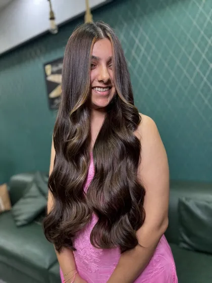 The ultimate goal for long hair: healthy, glossy, and full of life. This look features subtle face-framing highlights on a rich brown base, styled into soft, flowing waves that look effortlessly glamorous.