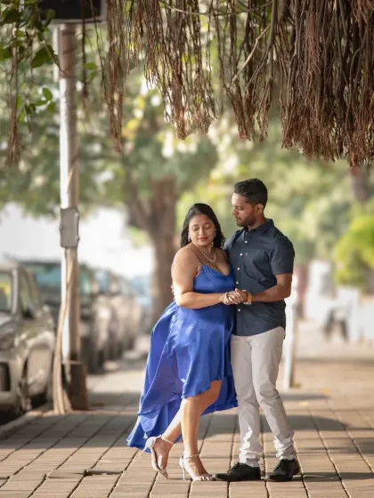 A romantic pre-wedding portrait on a tree-lined Mumbai street. The gentle breeze and soft focus on the background create a dreamy, urban fairytale feel.