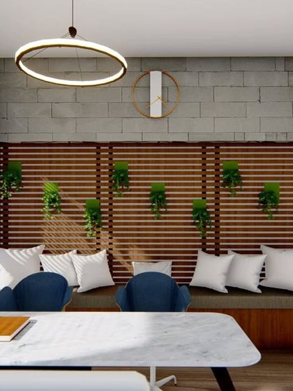 A comfortable breakout or informal meeting space within an office. The design uses a wooden slat wall with integrated planters and cozy bench seating to create a relaxing atmosphere.